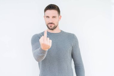 Soyutlanmış arka planda sıradan bir süveter giyen genç yakışıklı. Orta parmak, kaba ve kaba bir ifade sergiliyor.