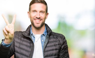 Yakışıklı adam kış ceket gösteren ve parmakları ile işaret ikincisi ise kendinden emin ve mutlu gülümseyerek.