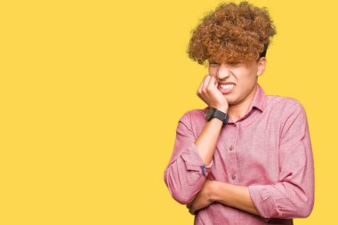 Stresli ve gergin elle çivi ısırma ağzına bakarak afro saçlı genç yakışıklı iş adamı. Anksiyete sorunu.