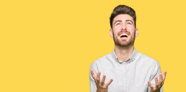 Genç, yakışıklı bir adam, sıradan bir gömlek giyiyor. Deli gibi bağırıyor, agresif bir ifadeyle bağırıyor ve kollarını kaldırıyor. hüsran kavramı.