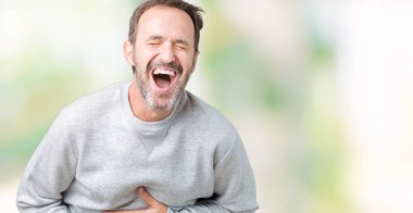 Bir kazak izole üzerinde giyen yakışıklı orta yaş üst düzey adam arka plan gülen ve komik deli şaka çünkü yüksek sesle zor gülüyor. Mutlu ifade.