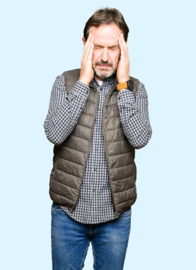 Orta yaş yakışıklı adam çünkü kafasına baş ağrısı için el ile kış yelek giyen stres. Migren muzdarip.
