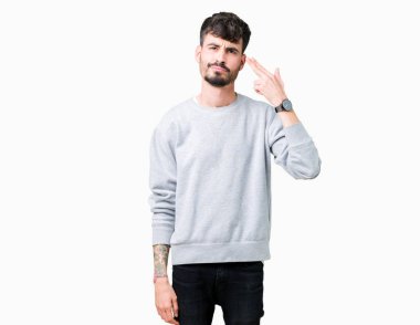 Genç yakışıklı adam giyen kazak izole üzerinde çekim ve öldürmek kendini el ve parmaklara baş, intihar jest işaret arka plan.