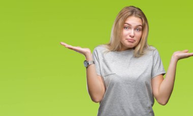 İzole arka plan clueless ve şaşkın bir ifadeyle kollar ve eller kaldırdı Genç beyaz kadın. Şüphe kavramı.