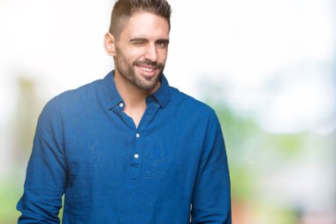 Genç yakışıklı adam seksi bir ifadeyle, neşeli ve mutlu yüzünü kameraya bakarak göz kırpıyor izole arka plan üzerinde.