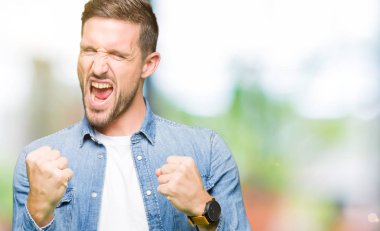 Kot giyen sakal ve mavi gözlü yakışıklı adamla ceket çok mutlu ve heyecanlı kaldırdı kollarını açarak kazanan jest yapıyor, gülümseyen ve başarı için çığlık. Kutlama kavramı.