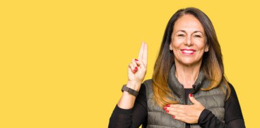 Kış yelek giyen güzel orta yaş kadın göğüs ve parmaklara el ile küfür, sadakat vaat yemini yapma