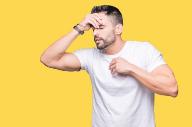 Sarı izole arka plan üzerinde beyaz t-shirt giyen Yakışıklı adam hastalık ve ateş, grip ve soğuk algınlığı, virüs hasta için alın dokunmadan