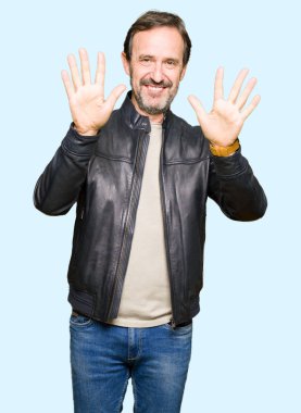 Orta yaş yakışıklı adam siyah deri ceket gösteren ve parmak numarası on ile işaret giymiş iken emin ve mutlu gülümseyen.