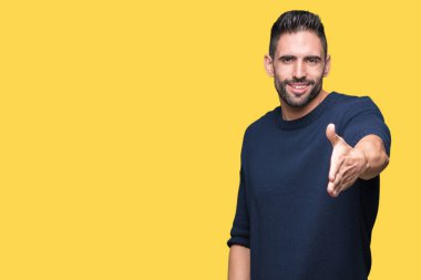 Yakışıklı genç dostu sunan karşılıklı tebrik ve davet edici gülümseyen izole arka plan üzerinde kazak giyiyor. Başarılı iş.