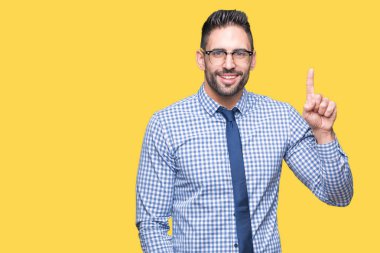 Ve parmak gülümseyen süre bir numara ile kendinden emin ve mutlu yukarıyı gösteren izole arka plan üzerinde gözlük takan genç iş adamı.