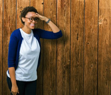 Genç güzel Afrikalı-Amerikalı kadın üzerinde gözlük takan arka plan çok mutlu ve gülümseyen uzakta el ile üzerine kafa seyir izole. Arama kavramı.