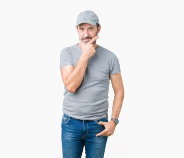 Emin çapraz kollar ve çeneme kaldırdı el ile gülümseme ile kameraya bakarak izole arka plan üzerinde spor şapkası yakışıklı orta yaş ağarmış komuta sizde. Pozitif düşünce.