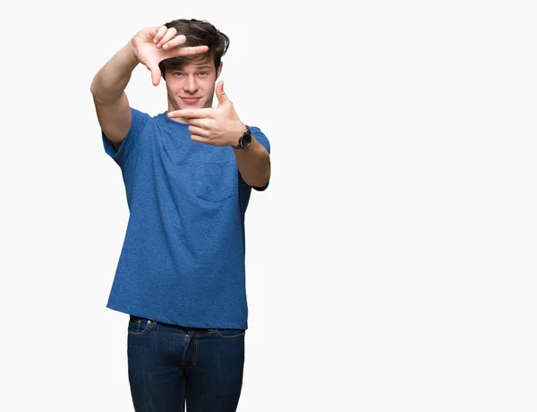 年轻的帅哥穿着蓝色T恤在孤立的背景微笑 用手和手指与快乐的脸框 创意与摄影理念 — 图库照片