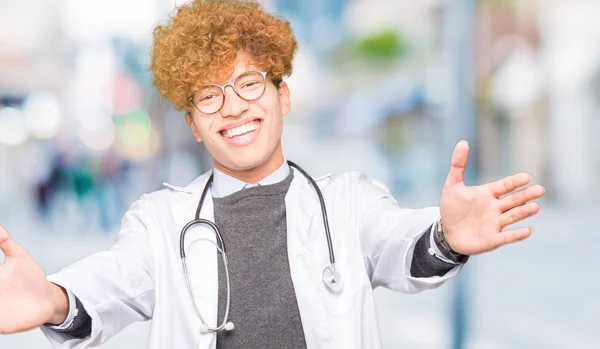 若いハンサムな医者はハグするため両手を広げて笑みを浮かべてカメラを見て医療のコートを着ている男 晴れやかな表情の受け入れ幸せ — ストック写真