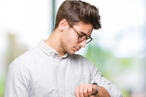 若いハンサムな男眼鏡をかけて分離背景上の腕時計 リラックスして自信を持って時間をチェックの上 — ストック写真