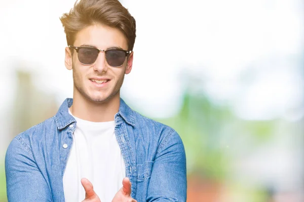 Jonge Knappe Man Dragen Zonnebril Geïsoleerde Achtergrond Smiling Met Handpalmen — Stockfoto