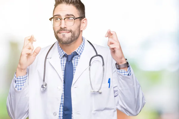 Bonito Jovem Médico Homem Sobre Fundo Isolado Sorrindo Cruzando Dedos — Fotografia de Stock