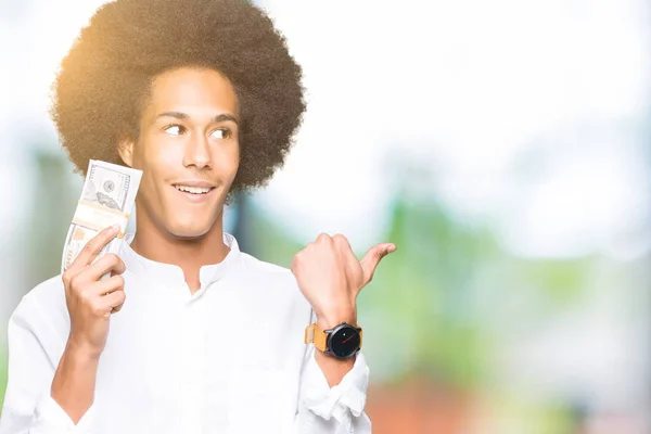 Joven Hombre Afroamericano Con Pelo Afro Sosteniendo Manojo Dólares Señalando —  Fotos de Stock