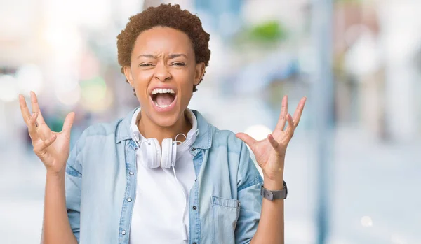 Mujer Afroamericana Joven Con Auriculares Sobre Fondo Aislado Loco Loco —  Fotos de Stock