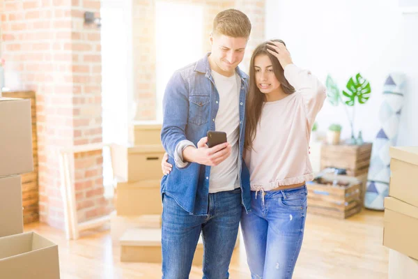 Bela Jovem Casal Mudar Para Uma Nova Casa Usando Smartphone — Fotografia de Stock