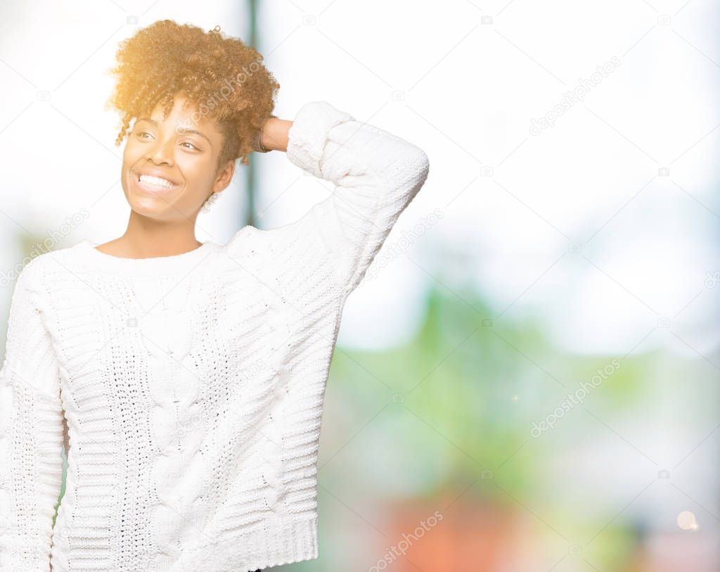 Beautiful young african american woman wearing winter sweater over isolated background Smiling confident touching hair with hand up gesture, posing attractive