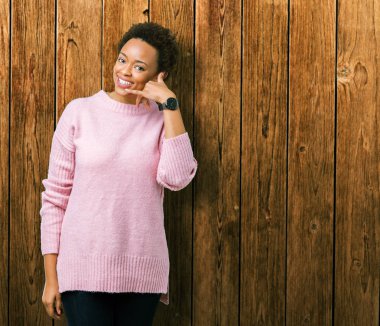 Güzel genç Afro-Amerikan kadın yapıyor gülümseyen izole arka plan üzerinde telefon hareketi ile el ve parmak telefonda konuşuyor gibi. Kavramları iletişim.