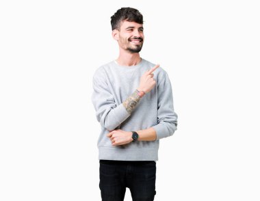 İzole arka neşeli bir gülümseme ile el ve parmak kadar yan yüzünde mutlu ve doğal ifade ile işaret yüz üzerinden sweatshirt giyen genç yakışıklı adam