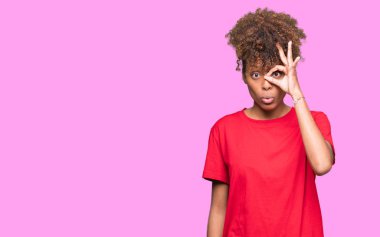 Sürpriz yüz, göz parmaklarının arasından seyir ile ok jest yapıyor izole arka plan güzel genç Afro-Amerikan kadın şok. İmansız ifade.