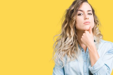 Güzel sarışın genç kadın emin çapraz kollar ve çeneme kaldırdı el ile gülümseme ile kameraya bakarak izole arka plan üzerinde. Pozitif düşünce.