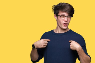 Yüzünde gülümseme ile kendinden emin görünüyorsun, kendini gururlu ve mutlu parmakları ile işaret izole arka plan üzerinde gözlük takan genç yakışıklı adam.