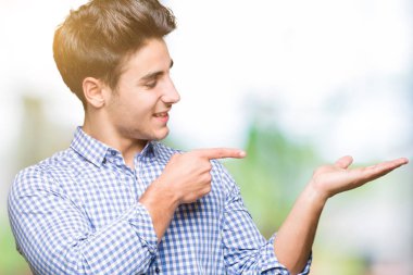 Genç yakışıklı iş adamı üzerinden hayran ve el ile sunulması ve parmak ile işaret ederken kameraya gülümseyen izole arka plan.