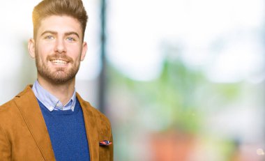 Hayret ve el ile sunulması ve parmak ile işaret ederken kameraya gülümseyen genç yakışıklı iş adamı.