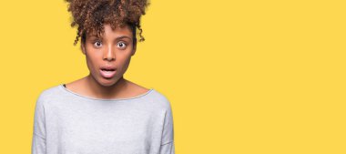 Güzel genç Afro-Amerikan kadın izole arka plan korkuyor ve sürpriz ifade ile şok yüzünden korku ve yüz heyecanlı.