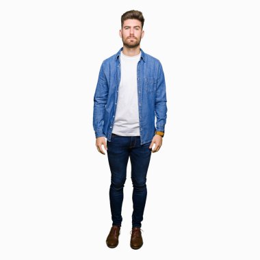 Yüzünde ciddi bir ifade ile Casual denim ceket giyen genç yakışıklı sarışın adam. Basit ve doğal kamera bakıyor.