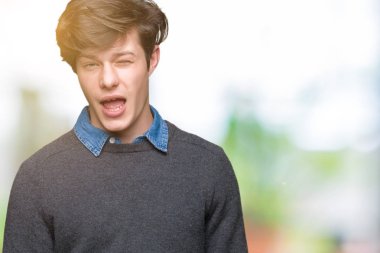 Genç yakışıklı zarif adam seksi bir ifadeyle, neşeli ve mutlu yüzünü kameraya bakarak göz kırpıyor izole arka plan üzerinde.