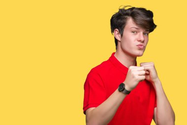 Kırmızı giyen genç yakışıklı adam t-shirt izole arka plan üzerine yumruk savunma hareketi, kızgın ve üzgün yüz, sorunu korkuyor ile savaşmaya hazır