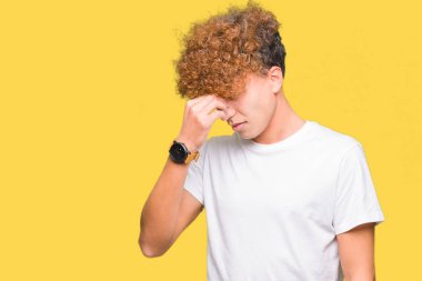 Casual beyaz t-shirt yorgun sürtünme burun ve göz yorgunluğu ve baş ağrısı duygu afro saçlı Genç yakışıklı adam. Stres ve hayal kırıklığı kavramı.