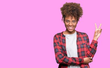 Mutlu yüz zafer işareti yaparken kameraya göz kırpıyor ile gülümseyen izole arka plan üzerinde gözlük güzel genç Afro-Amerikan kadın. İki numaralı.