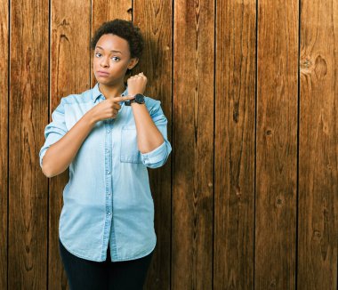 Acele işaretleme izlemek için zaman, sabırsızlık, üzgün ve kızgın son tarih gecikme için izole arka plan üzerinde genç güzel bir Afrikalı-Amerikalı kadın