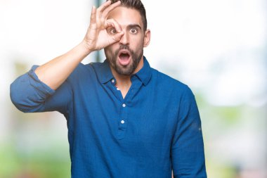 Sürpriz yüz, göz parmaklarının arasından seyir yakışıklı delikanlı ok jest yapıyor izole arka plan üzerinde şok. İmansız ifade.