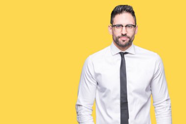 Üzerinde gözlük takan genç yakışıklı iş adamı arka plan gevşek yüzünde ciddi bir ifade ile izole. Basit ve doğal kameraya bakıyor.
