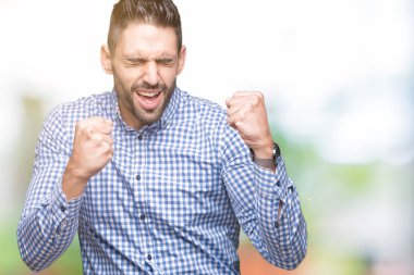 Soyutlanmış, mutlu ve heyecanlı genç bir adam kollarını kaldırmış, gülümseyen ve başarı için çığlık atan kazanan bir jest yapıyor. Kutlama konsepti.