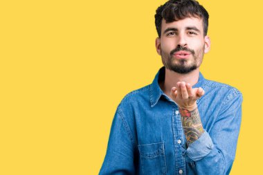 Yakışıklı delikanlı bir öpücük el ile güzel ve seksi olmak hava üfleme kamera bakarak izole arka plan üzerinde. Aşk ifade.