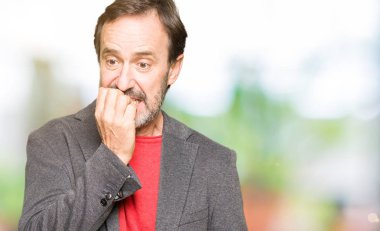 Orta yaş yakışıklı iş adam stresli ve gergin ile arıyorsunuz tırnak ısırma dudaklarından eller. Anksiyete sorunu.