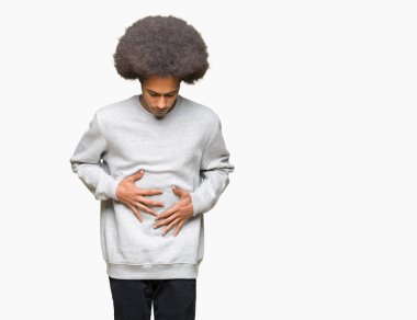 Çünkü mide üzerinde el ile sportif sweatshirt giyen afro saçlı genç Afro-Amerikan adam hazımsızlık, ağrılı hastalık hasta hissediyor. Ağrısı kavramı.