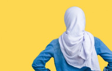 Geriye doğru uzakta silah ile vücut üzerinde seyir izole arka plan ayakta üzerinden Arap hijab giyen orta yaş Doğu Arap kadın