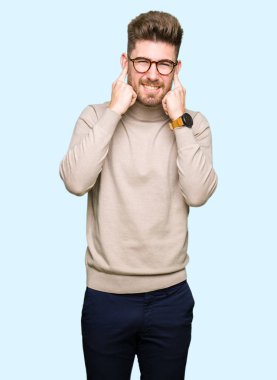 Yüksek sesle müzik gürültü rahatsız ifade parmaklarıyla kulaklarıyla kapsayan gözlüklü genç yakışıklı iş adamı. Sağır kavramı.