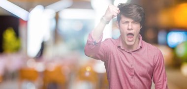 Genç yakışıklı iş adamı izole arka plan öfkeli ve sinirli sinirli ve öfke ile bağırarak süre öfkeli yumruk yükselterek üzerinde. Öfke ve agresif kavramı.