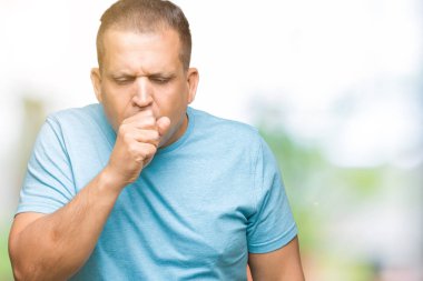 Orta yaş Arap adam duygu hasta ve soğuk veya bronşit için semptom olarak öksürük izole arka plan üzerinde mavi tişört giyiyor. Sağlık kavramı.